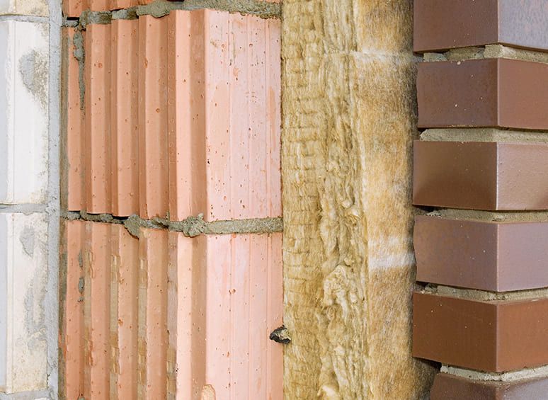 Wand wird mit Ziegelsteinen und Isoliermaterial gebaut